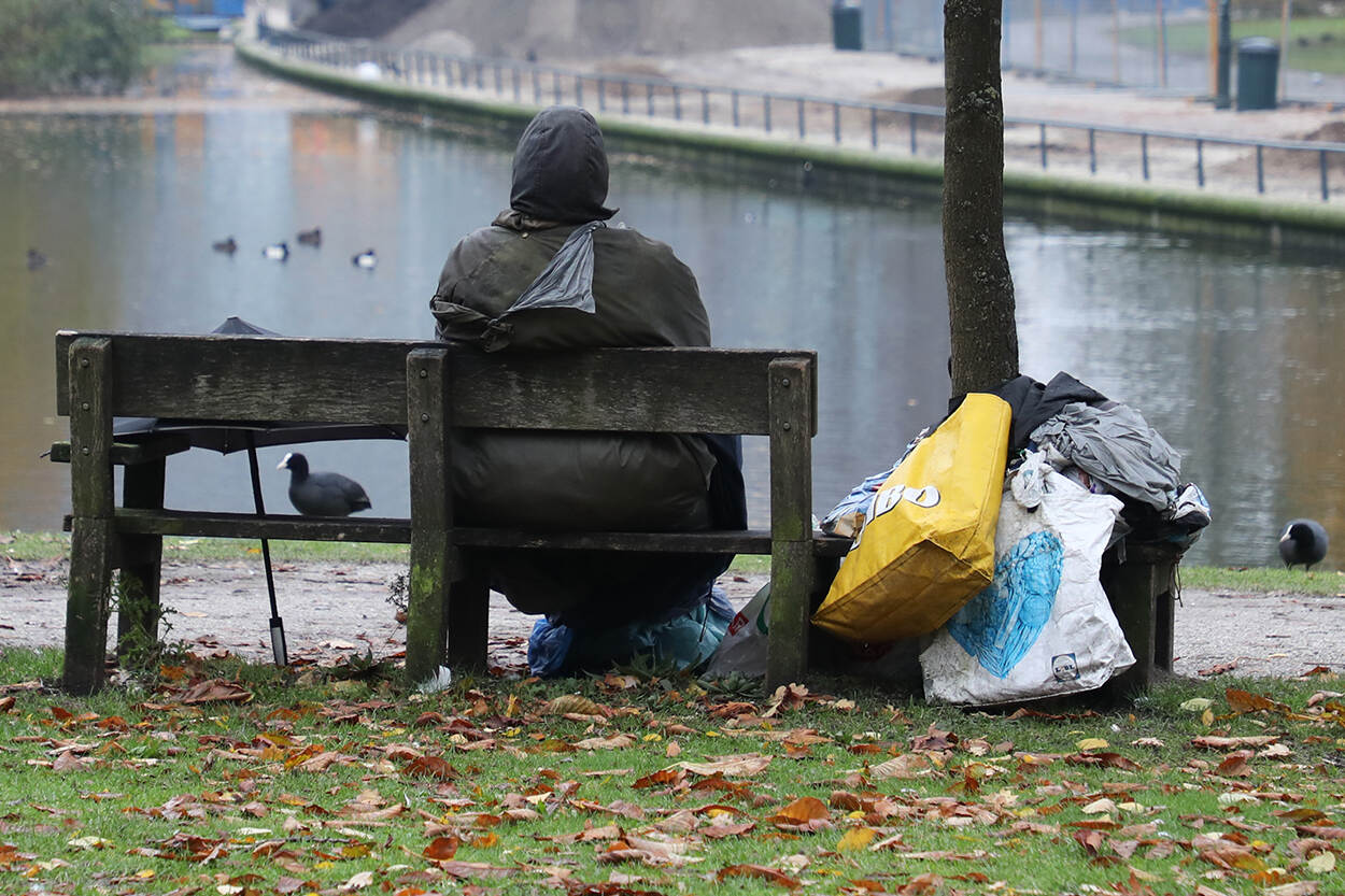 Dakloos persoon op een bankje in het park